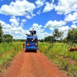 Tourists on top of bus to pick luggage, Teso, Uganda