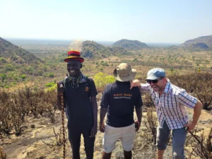 Three men enjoying their hike in Nyakwai Mountains, Rogom village, Karamoja, Uganda